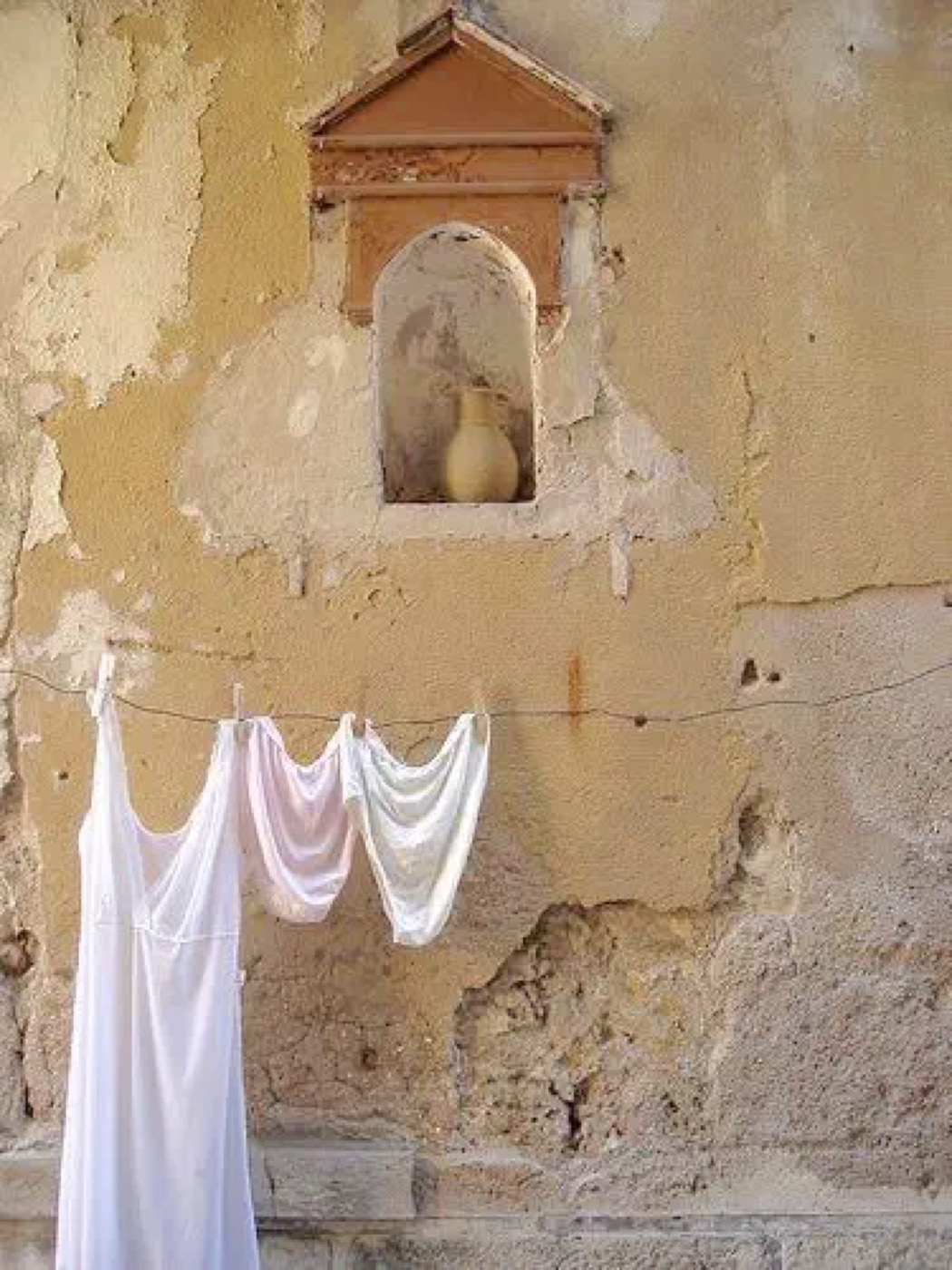 White linen drying on a stucco wall